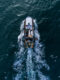 Fishing vessel boat floating in the blue sea, aerial top view from drone.