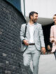 Happy business colleagues talking while walking through the city.